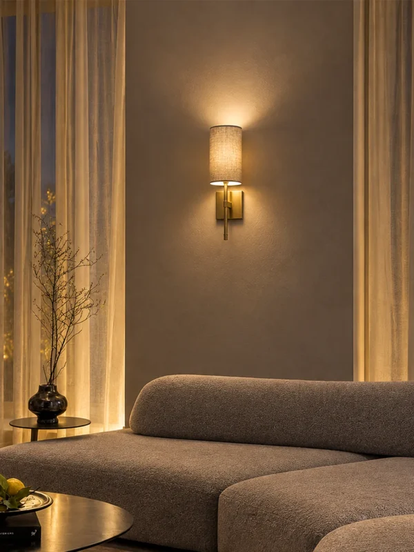 Serafina decorative wall lamp with a grey fabric shade mounted above a contemporary living room sofa