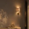 Serafina gold and grey fabric wall lamp providing soft illumination above a minimalist console