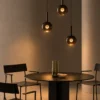 Sfera Glass Pendant Lights Contemporary Dining Room Three Sfera smoky glass pendant lights arranged at varying heights above a modern dining table