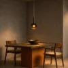 Sfera Pendant Light Modern Dining Room Sfera smoky glass pendant light suspended above a wooden dining table in a contemporary interior