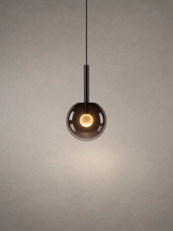 Sfera modern pendant light with a rounded smoky glass shade, black suspension stem, and illuminated center