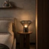 Silas table lamp providing warm illumination beside a bed