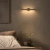 Suvi linear wall lamp above a bed in a modern bedroom