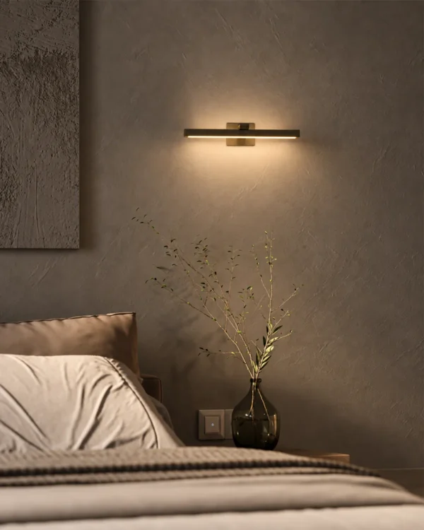 Suvi linear wall lamp above a bed in a modern bedroom