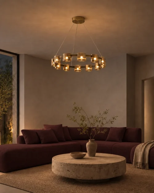 Svein gold and amber chandelier illuminating a modern living room with a burgundy sofa