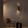 Virgil Black Wall Lamp Contemporary Interior Virgil black sculptural wall lamp providing warm accent lighting above a modern lounge chair
