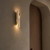 Virgil Wall Lamp Modern Hallway Virgil sculptural wall lamp mounted beside an arched wooden doorway in a contemporary hallway