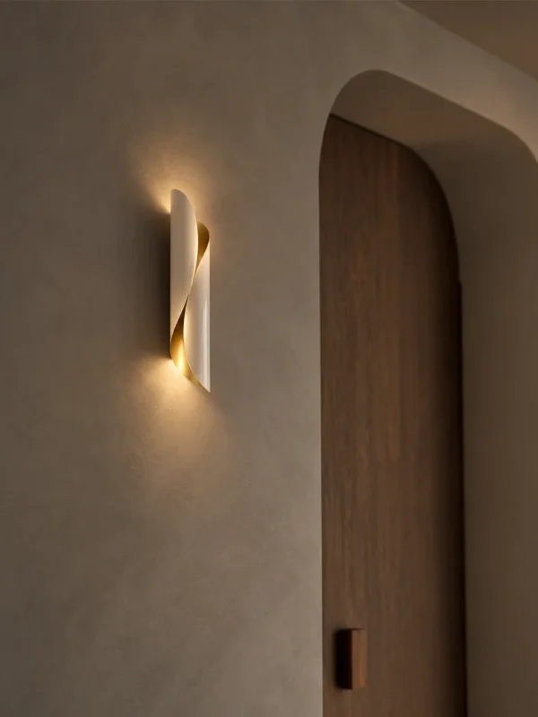 Virgil sculptural wall lamp mounted beside an arched wooden doorway in a contemporary hallway